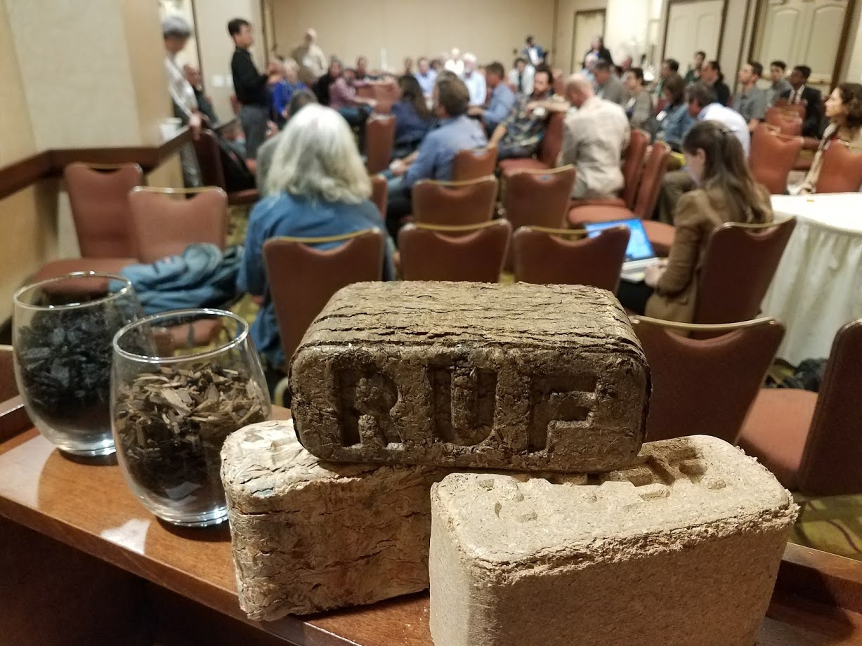 A briquette display with a lecture in the background.