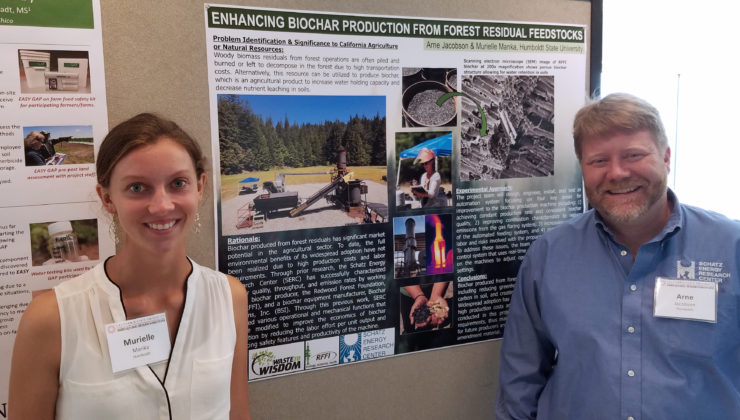 Murielle and Arne stand in front of a project poster.