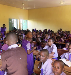 A full class of students works at their desks.