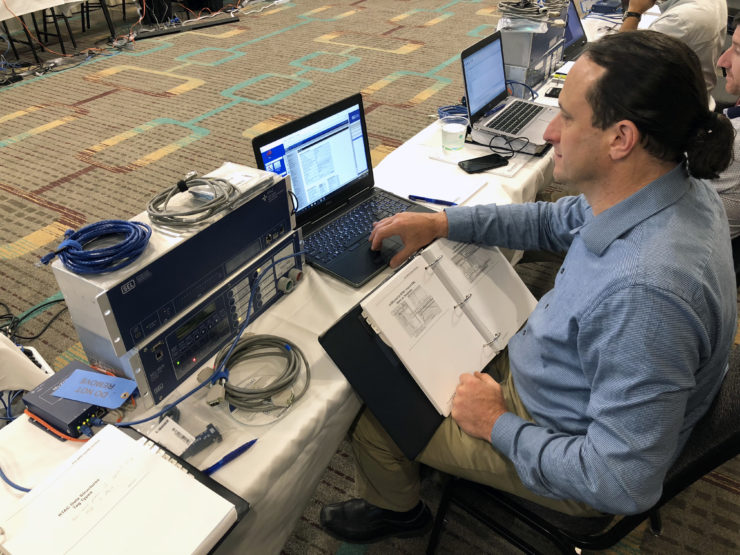 Dave Carter sits at a laptop connected to SEL equipment.