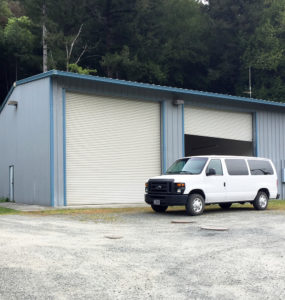 A white van is parked in front of the fire station