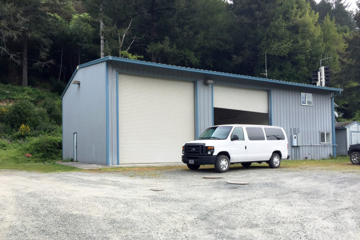 A white van is parked in front of the fire station