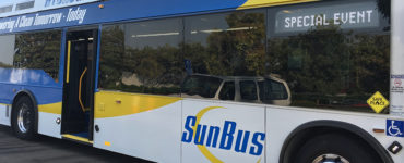 A hydrogen fuel cell "SunBus" sits outside a conference center.