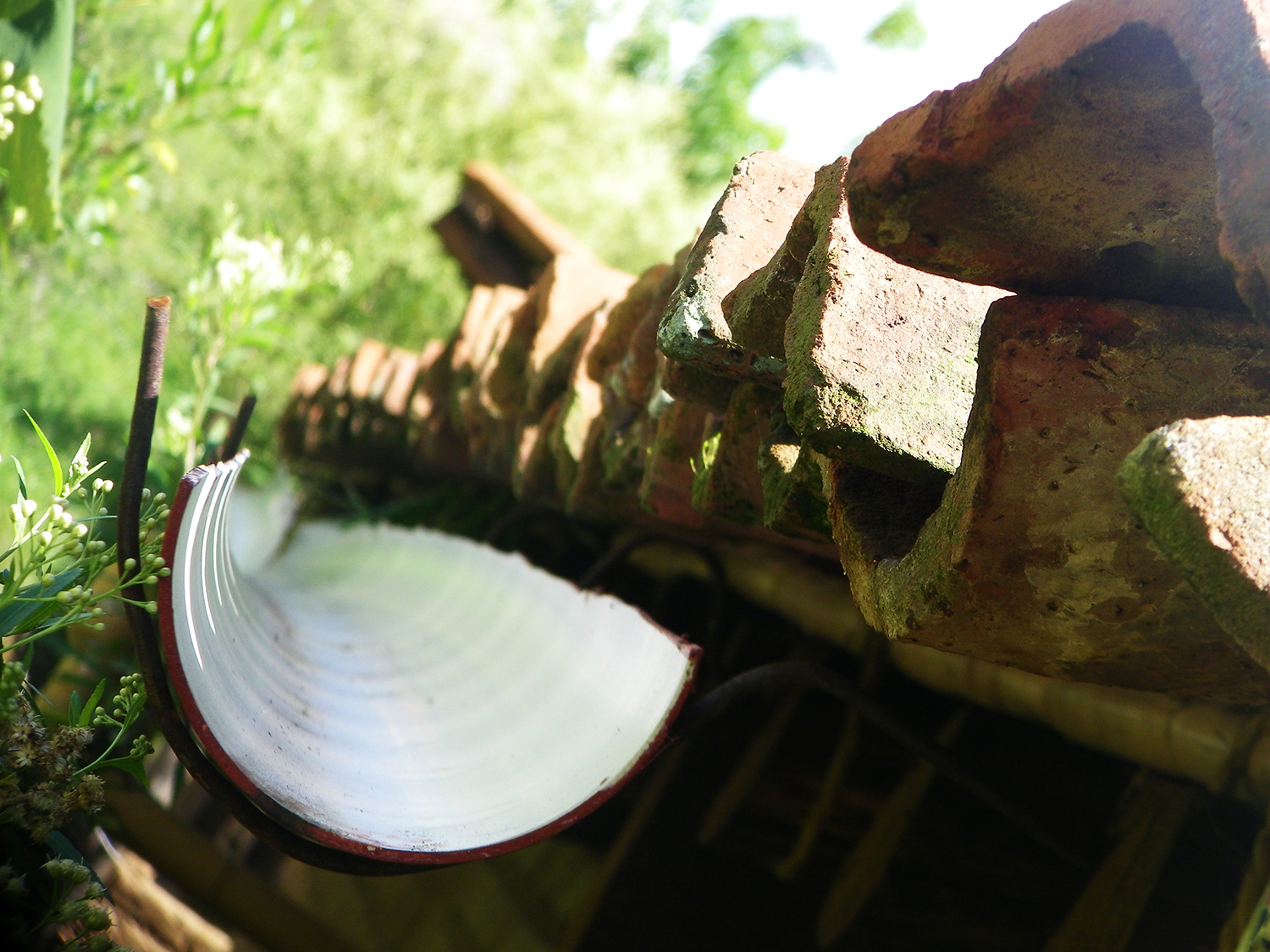 A pipe sliced in half to catch rain