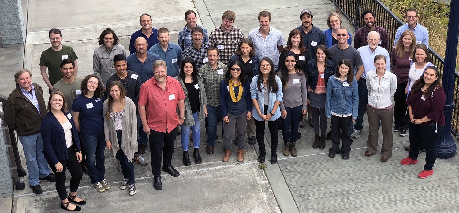 A group photo of 35 staff standing outside the Wharfinger Building in Eureka