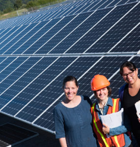 Three women stand at the foot of the Blue Lake Rancheria solar array.