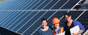 Three women stand at the foot of the Blue Lake Rancheria solar array.