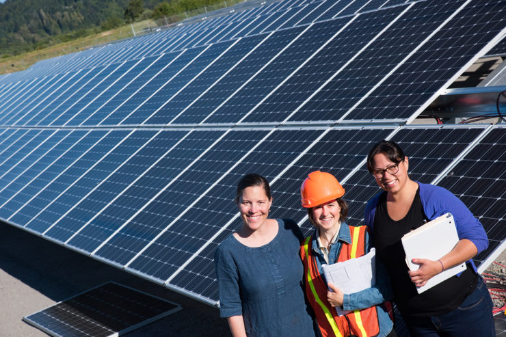 Three women stand at the foot of the Blue Lake Rancheria solar array.