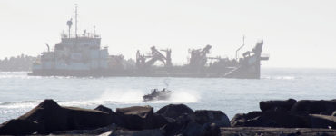 A dredge ship and small fishing boat in the mouth of Humboldt Bay)