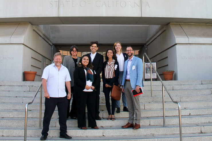 Researchers and Commissioner Douglas stand together on steps