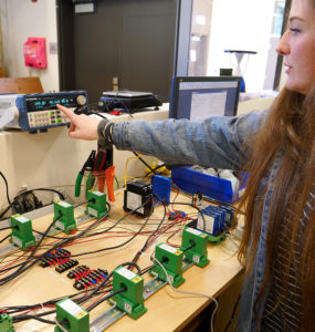 A woman points at output from a testboard