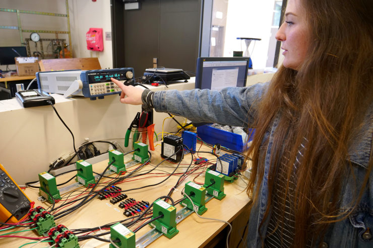 A woman points at output from a testboard