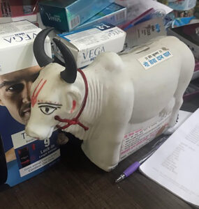 A plastic cow sits in front of mens' body products