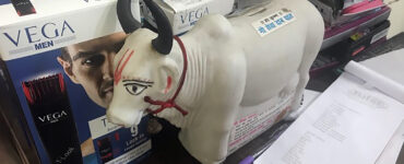 A plastic cow sits in front of mens' body products