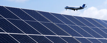 An airplane flies above the microgrid's solar array