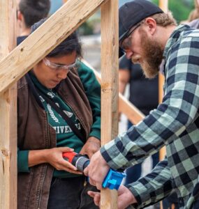 Two people work together to build a structure