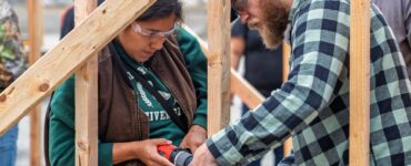 Two people work together to build a structure